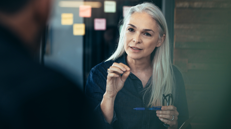 Woman talking to another person in an office.