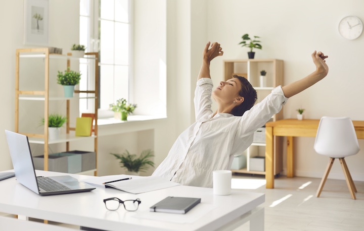 Woman stretches at her desk