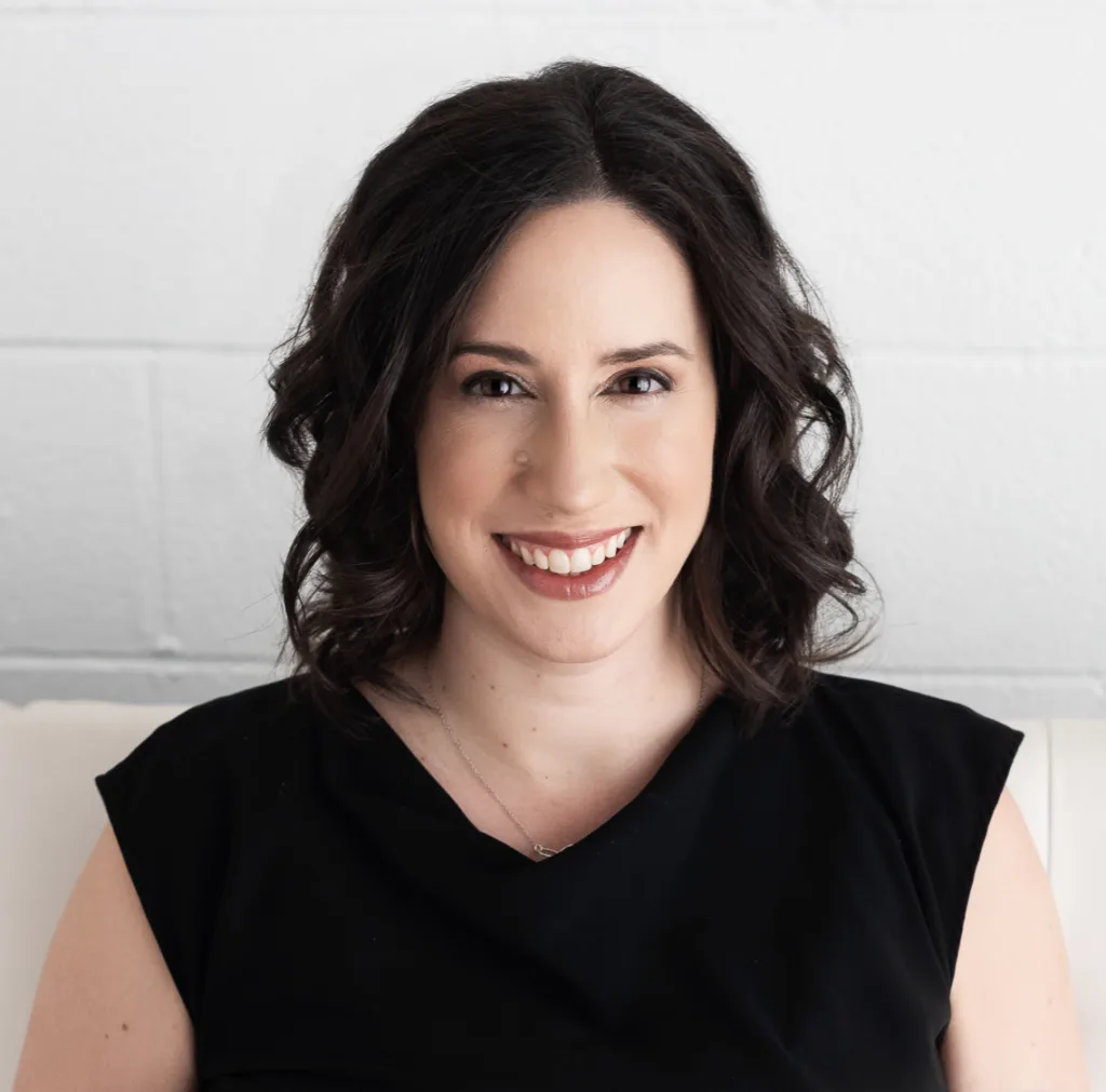 Business strategist and operations advisor Jessica Lackey is smiling to the camera in a black top