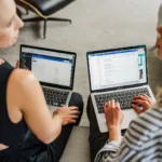 Nicki Krawczyk and Kate Sitarz working on their laptops together